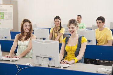 Deutschland, Emmering, Studenten benutzen Computer im Computerraum, lächelnd - RNF00346