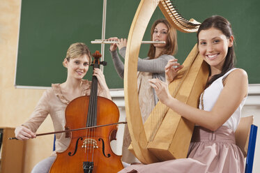 Deutschland, Emmering, Jugendliches Mädchen und junge Frauen spielen Musikinstrumente - RNF00343