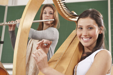 Deutschland, Emmering, Jugendliches Mädchen und junge Frau spielen Musikinstrumente - RNF00341