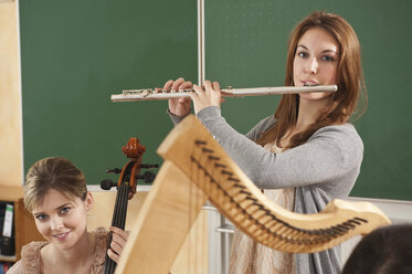 Deutschland, Emmering, Jugendliches Mädchen und junge Frau spielen Musikinstrumente - RNF00337