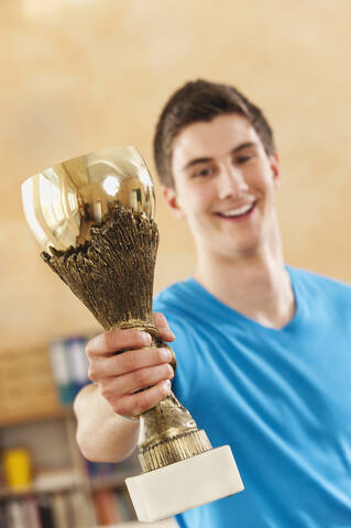 Germany, Emmering, Teenage boy holding trophy, smiling, portrait stock photo