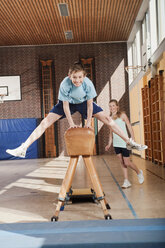 Germany, Emmering, Boy (12-13) jumping with girl standing in background - WESTF14619