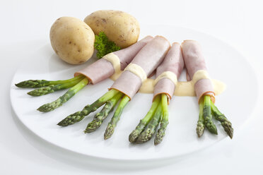 Asparagus with ham, potatoes and sauce in plate - MAEF02313