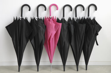 Schwarze Regenschirme mit einem rosa Regenschirm - ASF04105