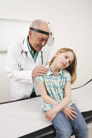 Germany, Munich, Doctor examining girl (8-9) in clinic stock photo