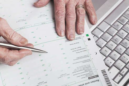 Deutschland, Seniorin mit Rentenbescheid und Laptop - GWF01164