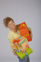 Junge Frau mit Geschenkpaketen, lächelnd, Porträt - CRF01876