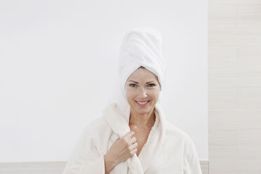 Germany, Woman with bathrobe in bathroom, smiling, portrait - WESTF14987