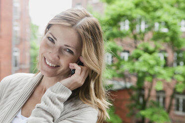 Germany, Woman talking on the phone, smiling, portrait - WESTF14929