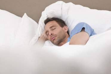 Deutschland, Mann schlafend auf Bett - WESTF14925