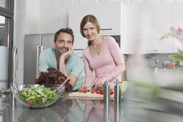 Germany, Couple preparing salad in kitchen, smiling, portrait - WESTF14886