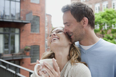 Deutschland, Paar genießt auf Balkon mit Frau mit Kaffeetasse - WESTF14881