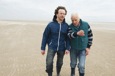 Deutschland, St. Peter-Ording, Nordsee, Älterer Mann und Sohn gehen am Strand spazieren - WESTF15066