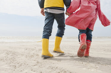 Deutschland, Nordsee, St.Peter-Ording, Kinder (6-9) in Stiefeln und Regenmänteln am Strand, tiefer Ausschnitt - WESTF15061