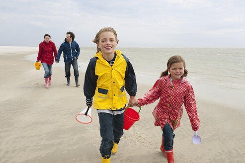 Deutschland, St. Peter-Ording, Nordsee, Kinder (6-9) mit Eltern beim Spaziergang am Strand - WESTF15050