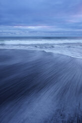 USA, Staat Washington, Olympic National Park, Blick auf verschwommene Wellen am dunklen Sandstrand - RUEF00416