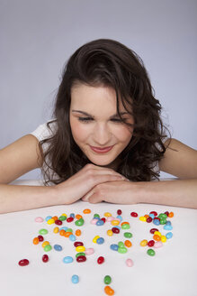 Junge Frau sieht sich lächelnd Süßigkeiten an - SKF00238