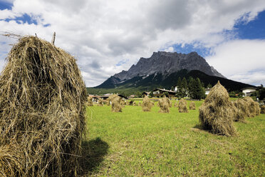 Österreich, Tirol, Zugspitz, Blick auf Heustadeln mit Bergen im Hintergrund - CSF013579