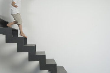 Germany, Low section of boy (4-5 years) moving down from stairs - CRF001911