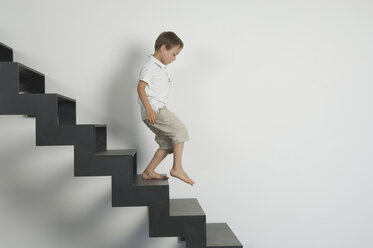 Deutschland, Junge (4-5 Jahre), der von der Treppe herunterkommt - CRF001913