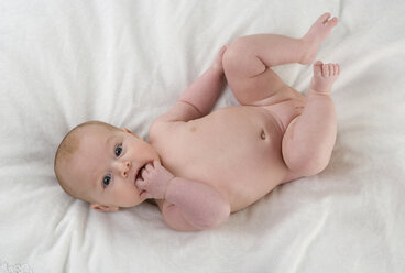 Baby girl (2-5 months) lying in bed, portrait - WWF001511