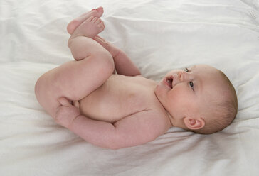 Baby girl (2-5 months) lying in bed - WWF001512