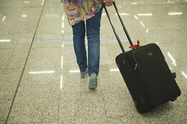 Spanien, Mallorca, Frau mit Koffer auf Flughafen - NHF001258