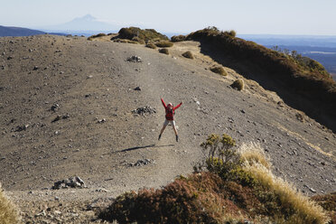 Neuseeland, Nordinsel, Frau springt auf vulkanische Moräne - GWF001234