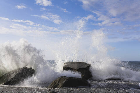 Neuseeland, Südinsel, Westküste, Blick auf Wasser, das auf einen Felsen spritzt, lizenzfreies Stockfoto