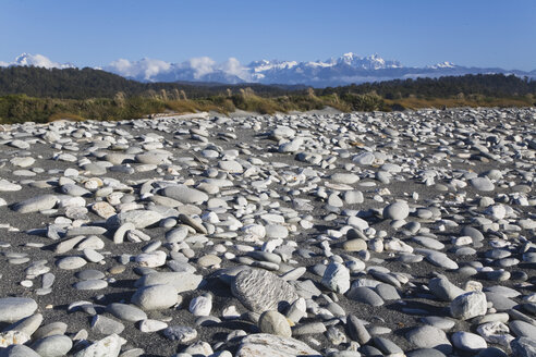 New Zealand, South Island, West Coast, View of west coast beach with mountains in background - GWF001324