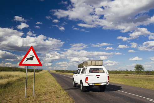 Afrika, Botswana, Landfahrzeug auf der Trans-Kalahari-Autobahn mit Straßenschild - FOF002162
