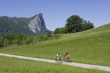 Österreich, Salzkammergut, Mondsee, Drachenwand, Junges Paar beim Radfahren - WWF001526