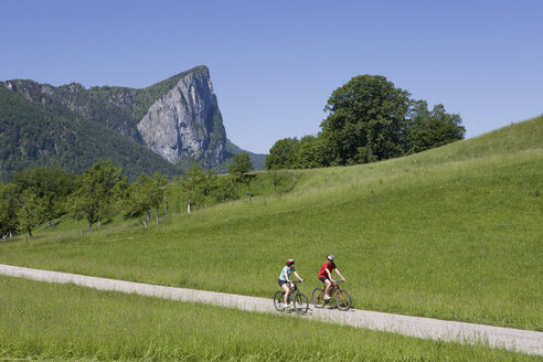 Österreich, Salzkammergut, Mondsee, Drachenwand, Junges Paar beim Radfahren - WWF001526