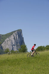 Österreich, Salzkammergut, Mondsee, Drachenwand, Junger Mann fährt Mountainbike - WWF001532