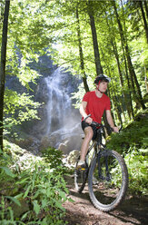 Österreich, Salzkammergut, Mondsee, Junger Mann fährt Mountainbike - WWF001533