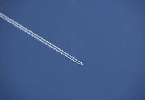 Österreich, Blick auf ein fliegendes Flugzeug in blauem Himmel - WWF001379