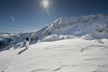 Austria, Salzburg, Altenmarkt-Zauchensee, Rear view of austrian woman skiing - HHF003372