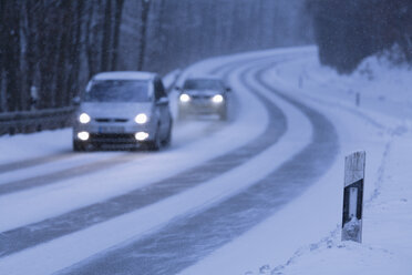 Deutschland, Bayern, Schaeftlarn, Autos auf Landstraße im Winter - TCF001350