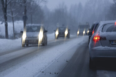 Germany, Bavaria, Buchenhain, cars on country road in winter - TCF001359