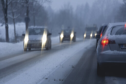 Deutschland, Bayern, Buchenhain, Autos auf Landstraße im Winter - TCF001359