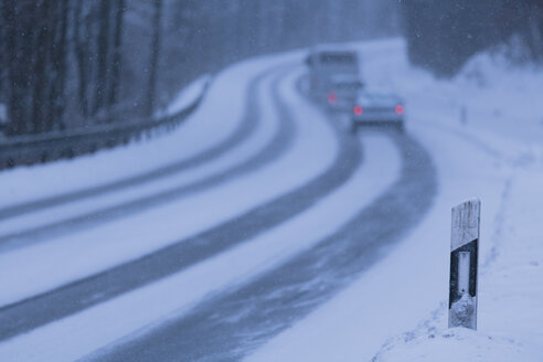 Deutschland, Bayern, Schaeftlarn, Blick auf fahrende Autos auf schneebedeckter Straße - TCF001339