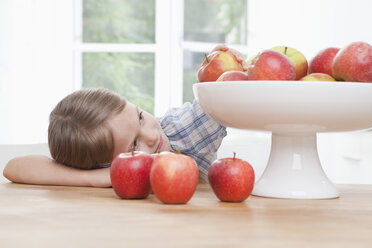 Deutschland, München, Mädchen (6-7) nimmt Apfel aus Schale - RBF000302
