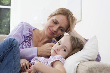 Germany, Munich, Mother with daughter (4-5) lying on sofa - RBF000288