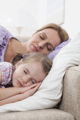 Germany, Munich, Mother and daughter (4-5) sleeping on sofa - RBF000286