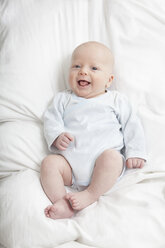 Deutschland, München, (2-5 Monate) kleiner Junge auf Bett, lachend - RBF000274