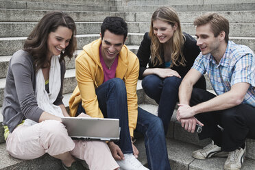 Deutschland, Berlin, Mann und Frau benutzen Laptop und diskutieren zusammen - WESTF015171