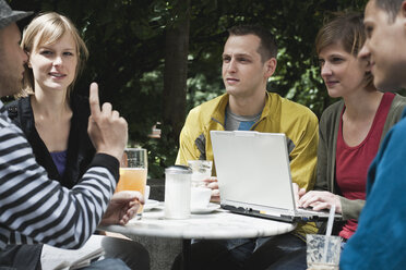 Deutschland, Berlin, Mann und Frau diskutieren zusammen und benutzen Laptop - WESTF015111