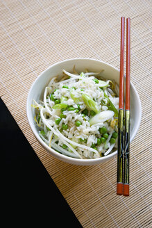 Gebratener Reis und Gemüse in Schüssel mit Stäbchen auf Untersetzer - PSF000607