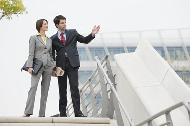 Germany, Hamburg, Business people standing discussing at stairway - WESTF015269