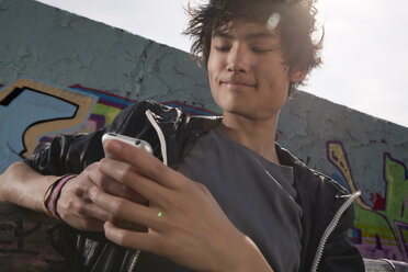 Germany, Berlin, Teenage boy using mobile phone - WESTF015292